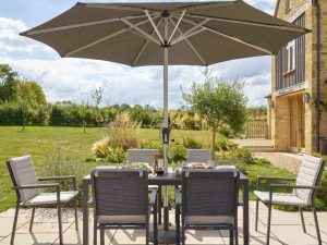 bramblecrest zurich 164 x 95cm rectangle tree free table with 6 chairs & parasol eco fawn X23AZR164RT1 lifestyle 2